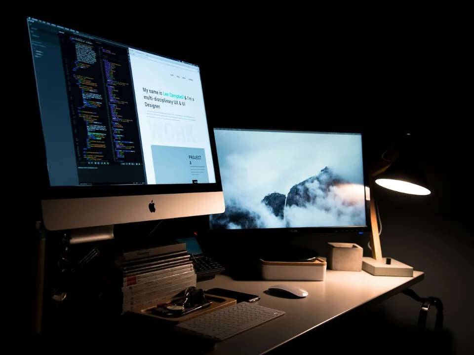 Desk with monitors showing a website design